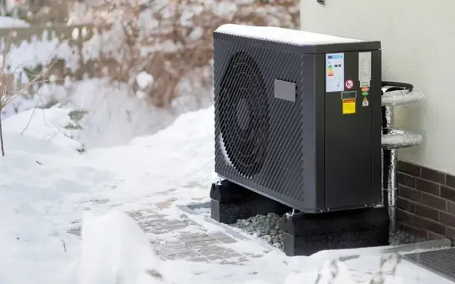 Pompe à chaleur air-eau en hiver à Sion — groupe extérieur sous la neige